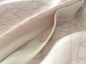 A dress shirt in blush and grey colors by Babaton, an Aritzia brand.