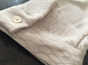 A dress shirt in blush and grey colors by Babaton, an Aritzia brand.