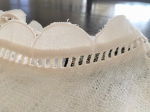 Scallop mock neck with ladder stitching detail.